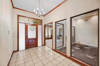 Foyer featuring crown molding, light tile patterne