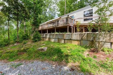 Back side of home and gravel drive down to lake