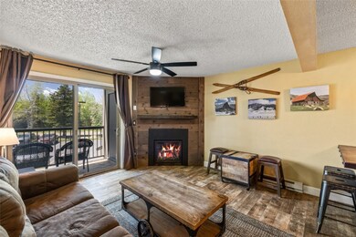Living room featuring ceiling fan, a textured ceil