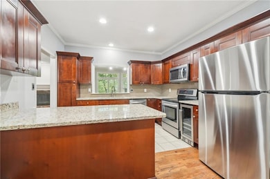 Kitchen with tasteful backsplash, a peninsula, app