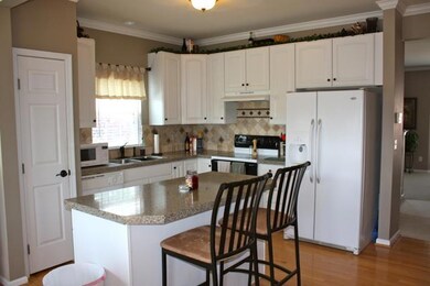 Renovated kitchen with granite counter tops, island bar, tile back splash, gleaming hardwoods, pantry, and refrigerator can stay!