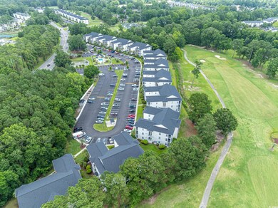 Aerial overview of property's location featuring a tree filled landscape and nearby suburban area