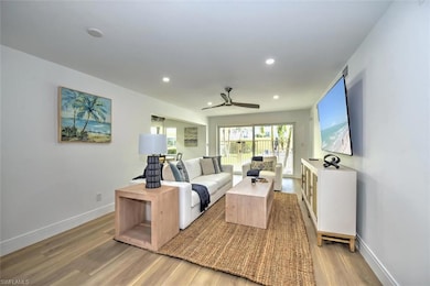 Living room with light wood finished floors, ceiling fan, recessed lighting, and baseboards