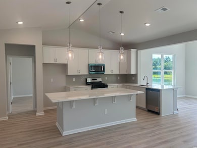 Kitchen featuring appliances with stainless steel finishes, a sink, a peninsula, white cabinets, and backsplash