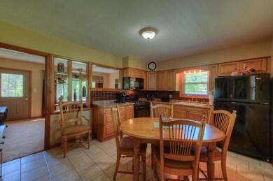REMODELED EAT IN KITCHEN WITH MAPLE CABINETS AND GLASS BACK SPLASH AND APPLIANCES STAY