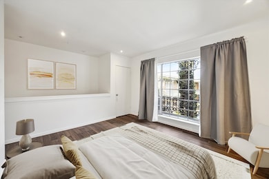 Bedroom has wood floors and a beautiful divided gl