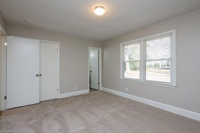 Primary Bedroom: Features include new carpet flooring to help keep your feet warm on cool mornings, 2 windows for natural lighting with blinds for privacy and fresh new paint. The primary bathroom is to the right side, the double door closet is in the middle and the entry door is to the left side.
