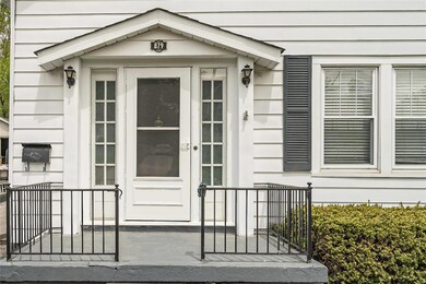 The central feature of the facade is the Entry system with original sidelights and a gable treatment that crowns the front porch.  Coach lights frame the space.