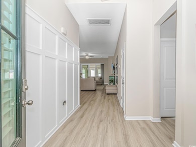 Foyer entrance featuring light wood-type flooring, ceiling fan, and baseboards