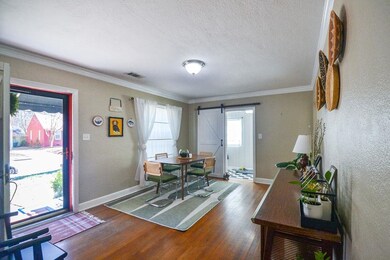 Dining area featuring a barn door, baseboards, and wood finished floors