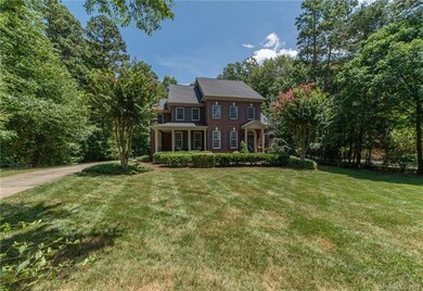 Large front yard surrounded by trees providing ton