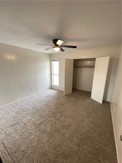 Unfurnished bedroom with carpet, a ceiling fan, an