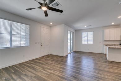 Unfurnished living room with dark wood-type flooring, baseboards, visible vents, ceiling fan, and recessed lighting