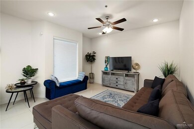 Living room featuring light tile patterned floors and ceiling fan