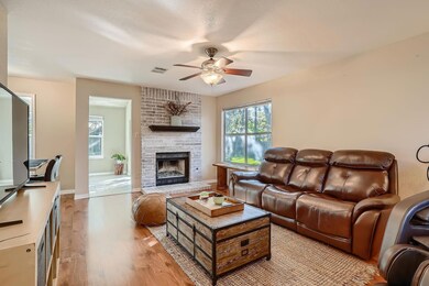 Living area featuring ceiling fan, light wood-sty