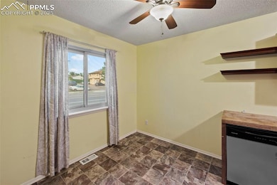 Unfurnished dining area with a textured ceiling, ceiling fan, and stone finish flooring