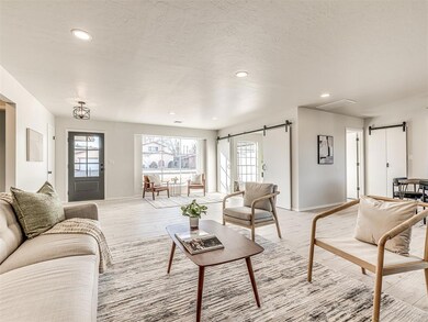 Living room with a barn door, a textured ceiling, 