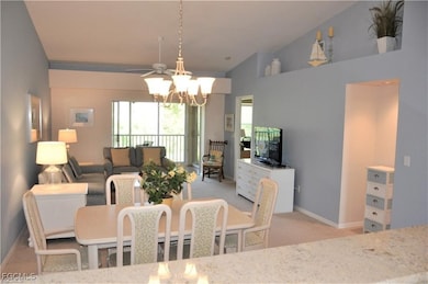 Dining room featuring a chandelier, light carpet, and high vaulted ceiling