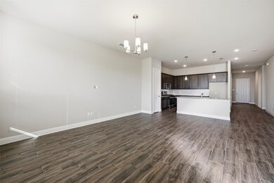 Kitchen with open floor plan, pendant lighting, a chandelier, light countertops, and dark brown cabinetry