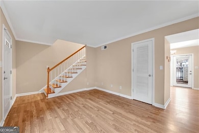 Foyer with crown molding and light wood-type floor