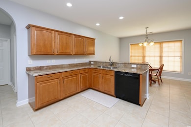 Kitchen featuring dishwasher, a sink, a peninsula,
