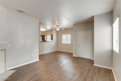 Unfurnished living room featuring plenty of natural light, light wood-style flooring, ceiling fan, a fireplace, and a textured ceiling