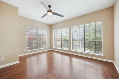 Empty room featuring a ceiling fan and wood finis
