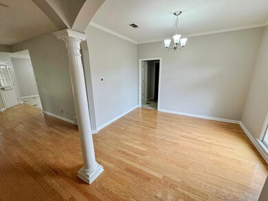 Spare room featuring ornate columns, light hardwoo