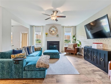 Living area featuring a ceiling fan, plenty of nat
