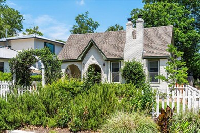 Tudor house featuring a shingled roof and a chimn