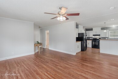Unfurnished living room featuring ceiling fan, har