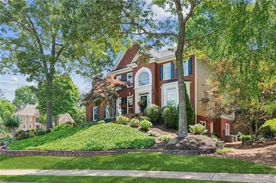 Colonial home with central AC unit and brick siding