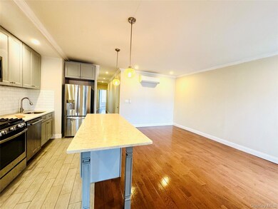 Kitchen with tasteful backsplash, crown molding, gray cabinetry, pendant lighting, and appliances with stainless steel finishes