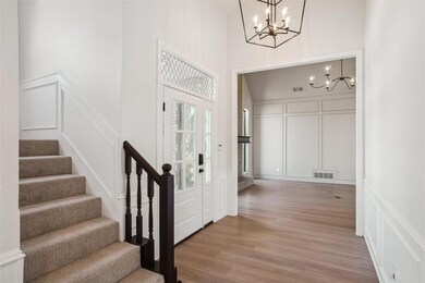 Entryway featuring a chandelier, stairway, a decor