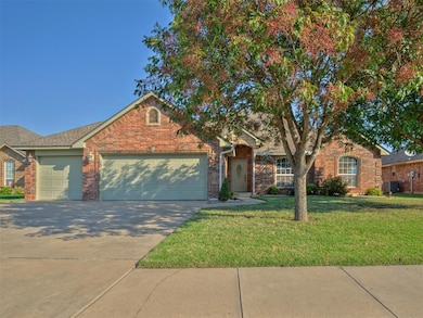 View of front of house featuring concrete driveway, a front lawn, a garage, and brick siding