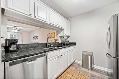 Kitchen featuring sink, light hardwood / wood-style flooring, stainless steel appliances, and white cabinets