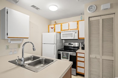 Kitchen featuring white appliances, visible vents,