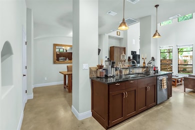 Kitchen with finished concrete floors, a sink, ap