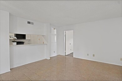 Unfurnished living room featuring a textured ceili