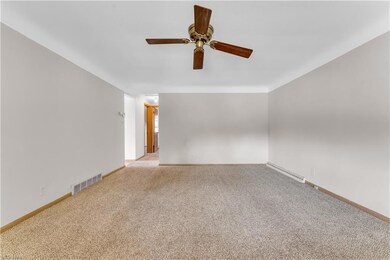 Carpeted spare room featuring ceiling fan