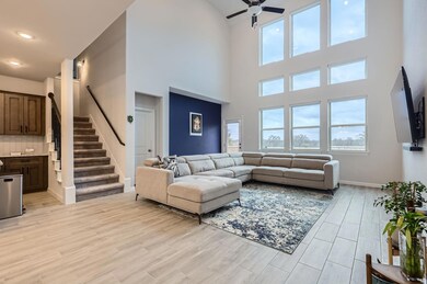 Living area featuring a ceiling fan, stairs, a to