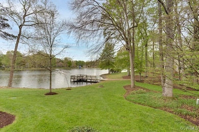 View of dock from deck, featuring a yard and a wat