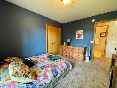 Leaving the third bedroom. Bi-fold closet doors on the far left. The main floor full bathroom is visible across the hallway.