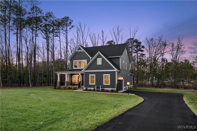 View of front of property with a yard, a porch, a garage, and driveway
