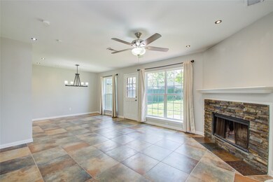 Step into the light and bright living room.  Living room has tiled floors, recent paint and ledger rock on the fireplace.   No carpet in the entire house.