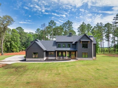 View of front of home featuring board and batten siding, a front lawn, roof with shingles, and a standing seam roof