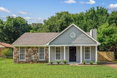 View of front of home featuring a chimney, stone siding, covered porch, a shingled roof, and a gate