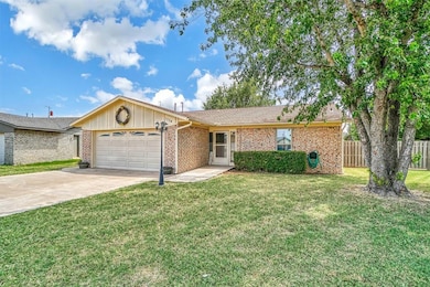 Ranch-style house featuring a garage and a front y