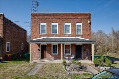 View of property with brick siding, a porch, and a