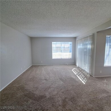 Carpeted empty room with a textured ceiling, baseb